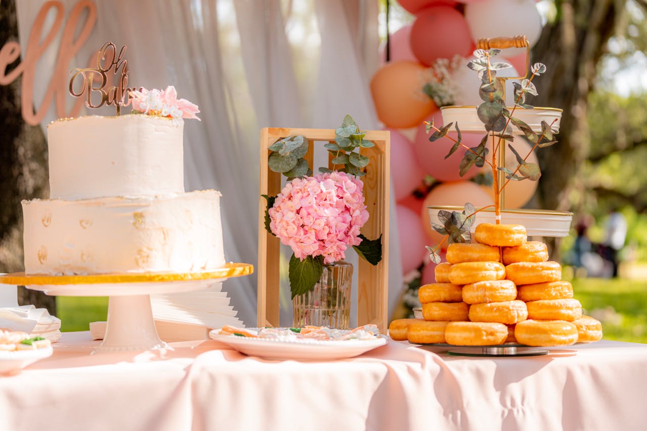 Mastering the First Impression: Your intriguing post title goes here A beautifully decorated outdoor dessert table set for a baby shower featuring a cake and donuts.