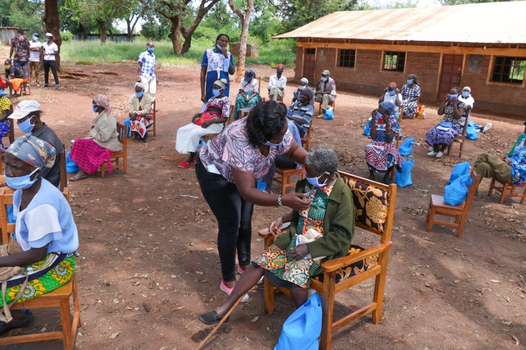 pexels photo 4483669 Aid workers assist elderly people with healthcare support in a rural setting.